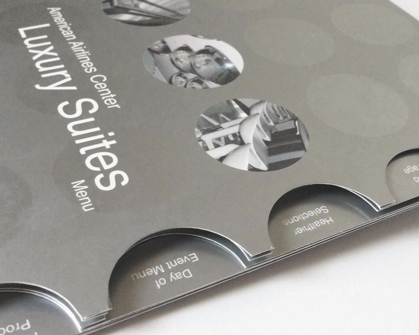Close-up of the Luxury Suites menu cover with photo-filled circle windows and round index tabs for Day of Event Menu and Healthier Selections