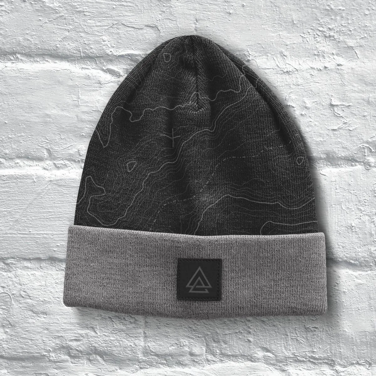 Black topographic-print beanie with a grey cuff and a leather APODOKIA patch