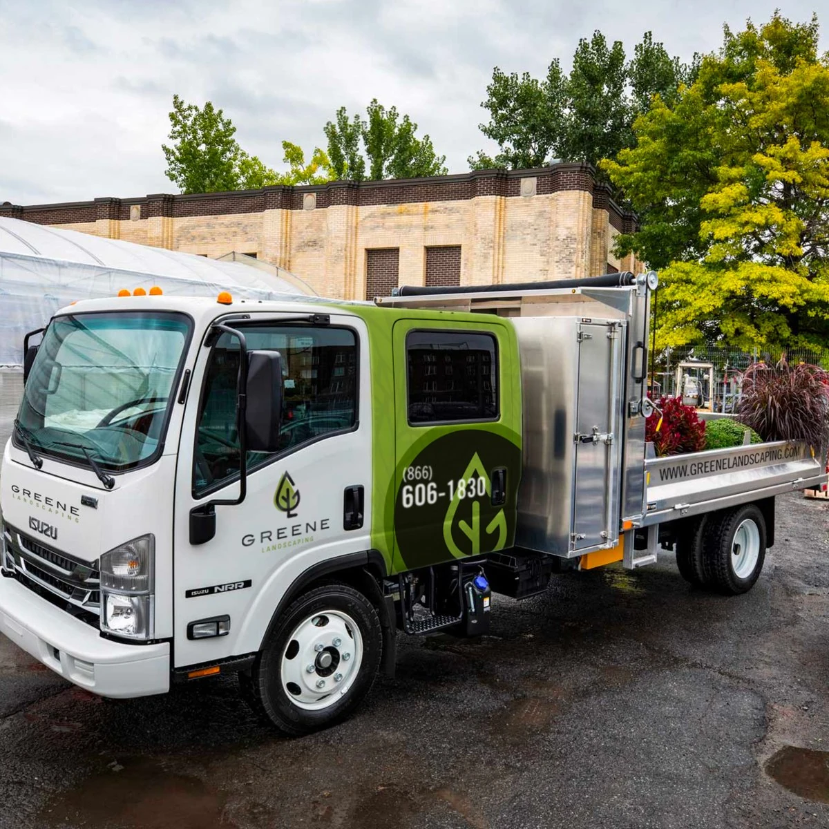 White GREENE Landscaping crew truck with a green and charcoal wrap, phone number and leaf mark