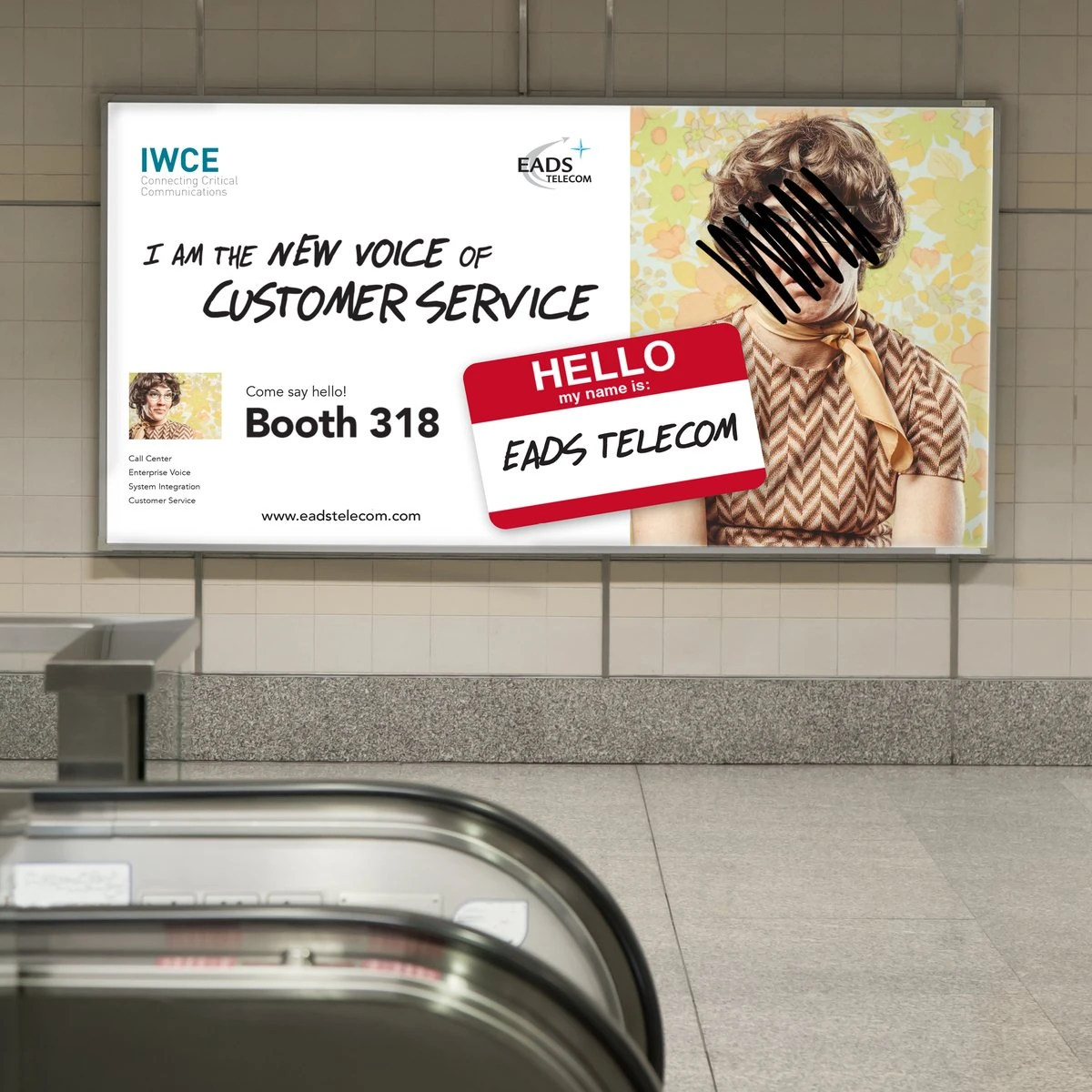 EADS Telecom IWCE billboard “I am the new voice of customer service, Booth 318” in a transit station