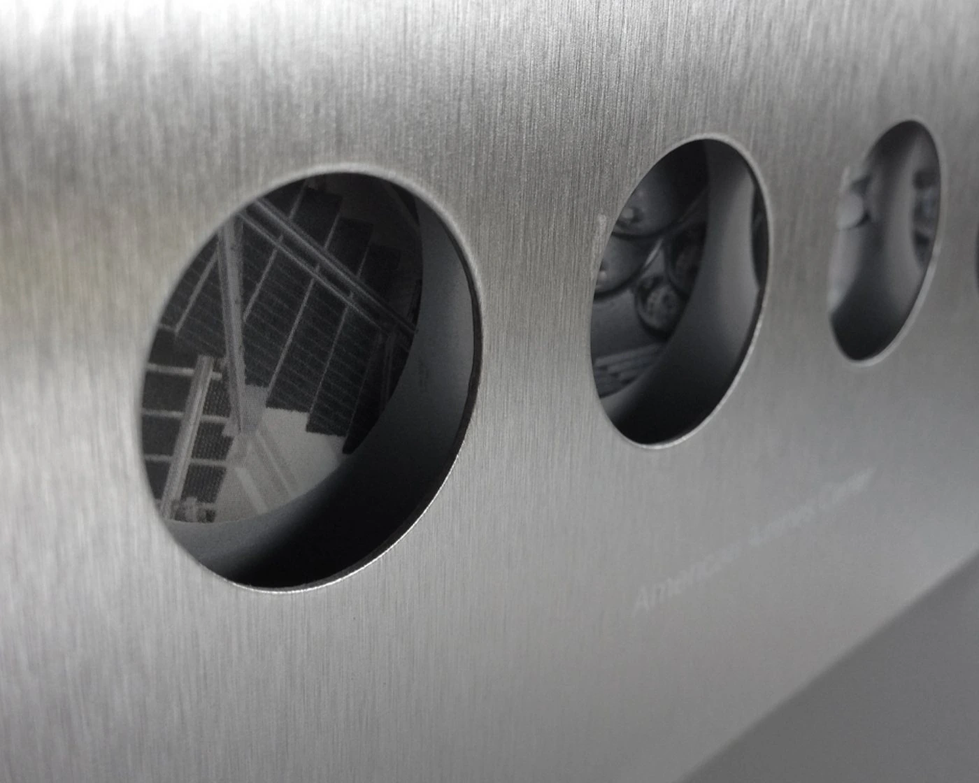 Brushed-metal cover with die-cut circles showing black-and-white photos of the suites
