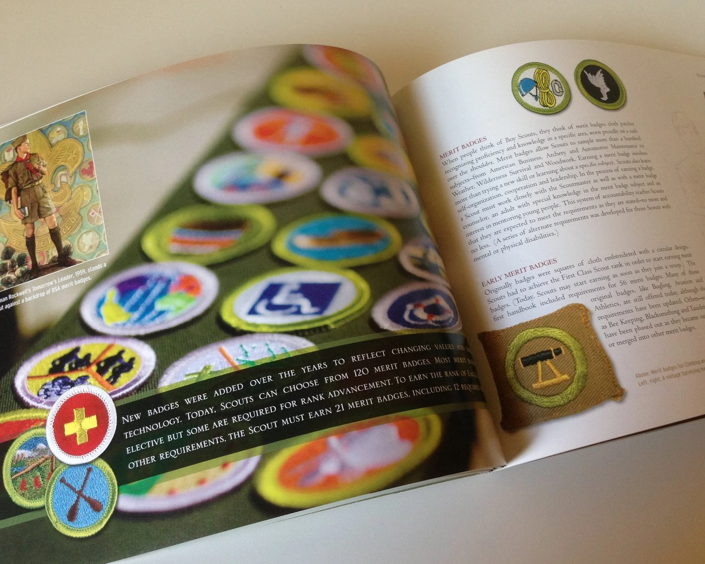 Open merit badge spread with a close-up of embroidered badges and a Norman Rockwell painting