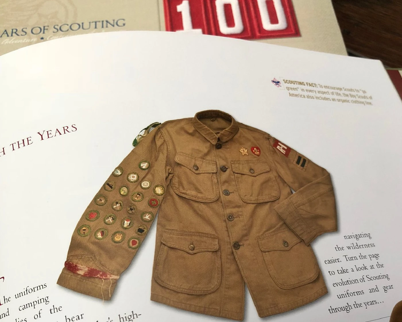 An original Scout jacket covered in merit badges, on the opening page of Gear Through the Years