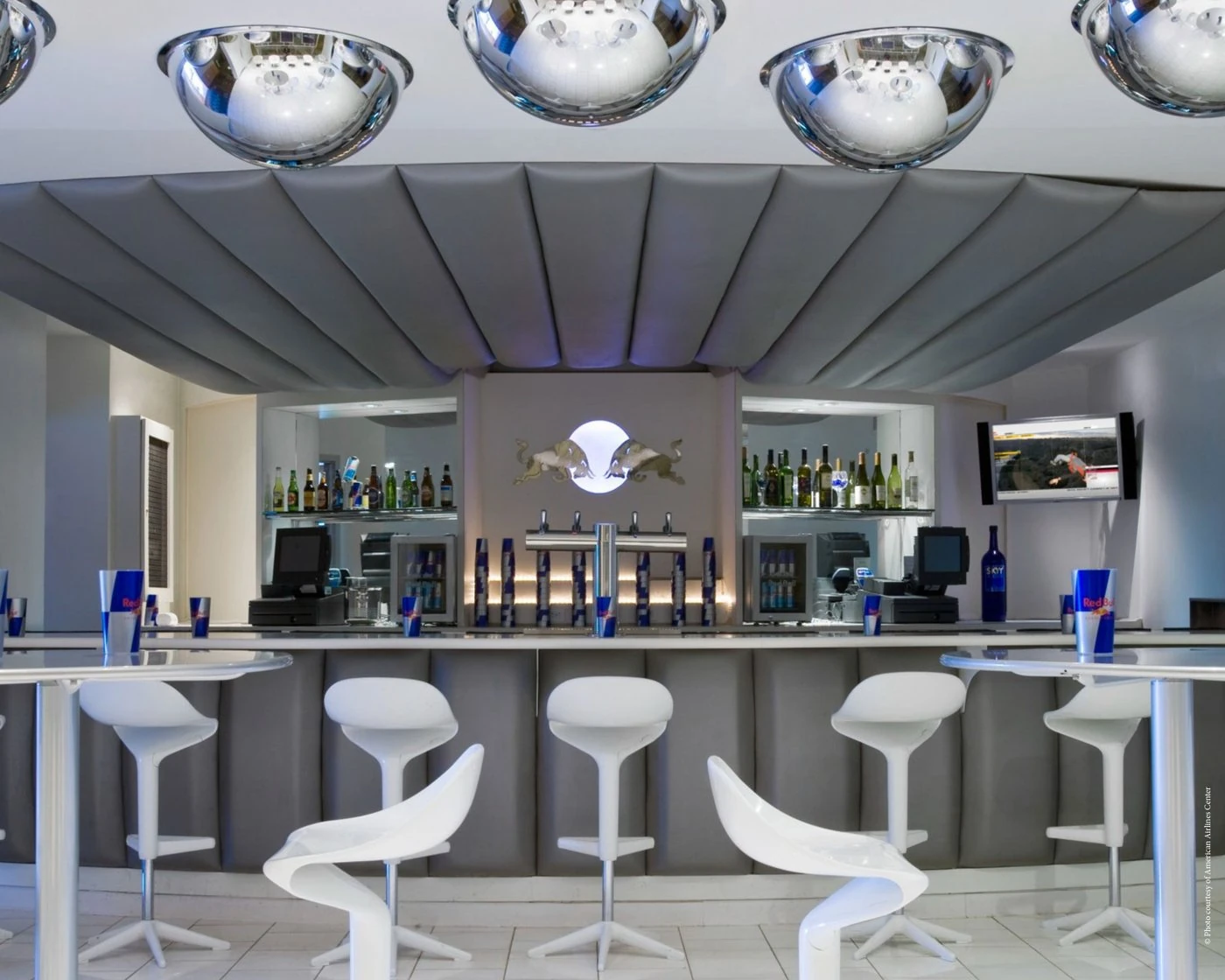 Suite-level bar with mirrored ceiling domes, a padded silver canopy and white sculptural stools